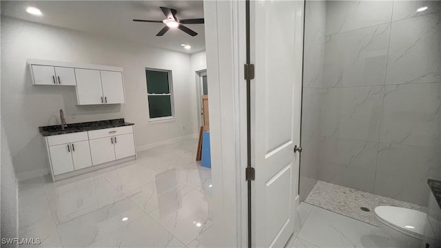 full bathroom with vanity, a ceiling fan, baseboards, marble finish floor, and a marble finish shower