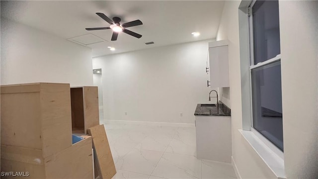 interior space with visible vents, baseboards, ceiling fan, marble finish floor, and a sink