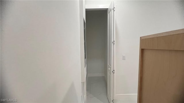 hallway with marble finish floor and baseboards