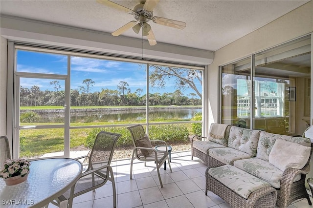 sunroom featuring a water view and a ceiling fan