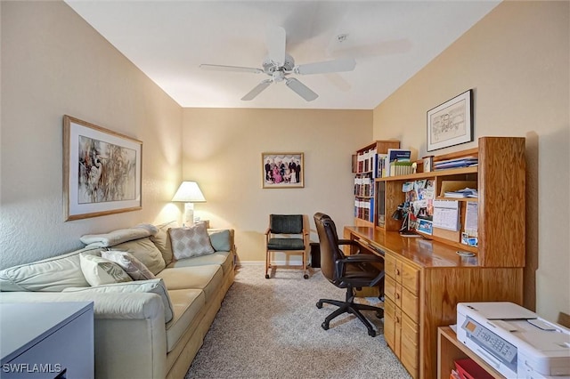 home office with baseboards, a ceiling fan, and light colored carpet