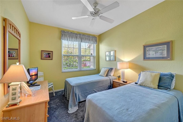 bedroom with ceiling fan, dark colored carpet, and baseboards