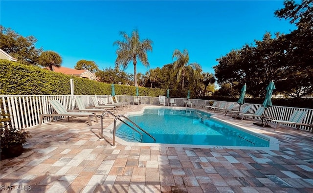 pool with a patio area and fence