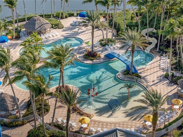 pool with a water slide, a water play area, and a hot tub