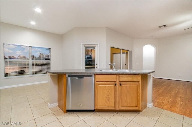 kitchen with light tile patterned floors, visible vents, arched walkways, stainless steel dishwasher, and a sink