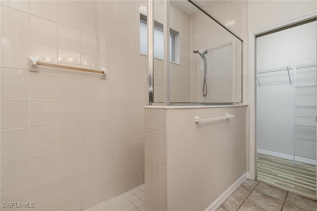 bathroom with a walk in shower and baseboards