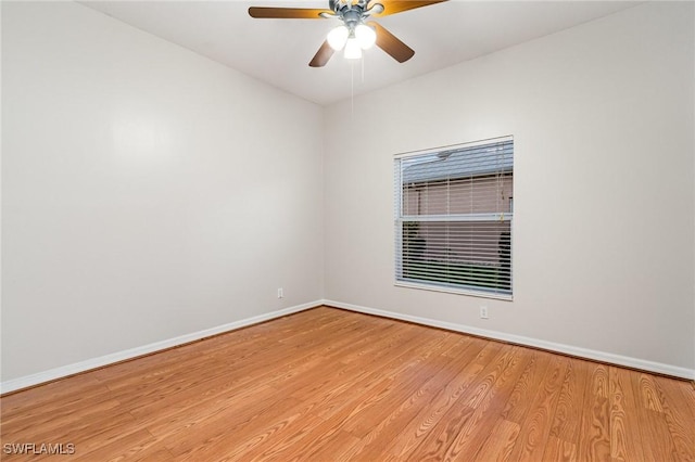 spare room with a ceiling fan, baseboards, and wood finished floors