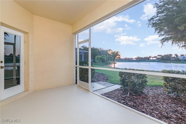 unfurnished sunroom featuring a water view