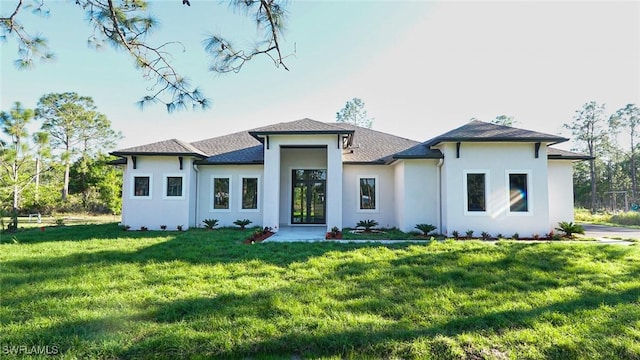 prairie-style home featuring a front lawn and stucco siding