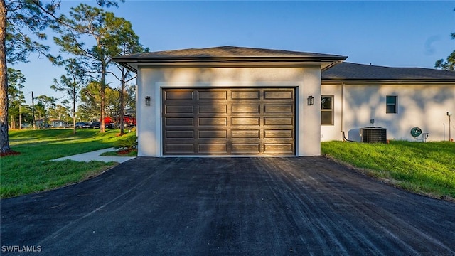 garage featuring aphalt driveway and central AC