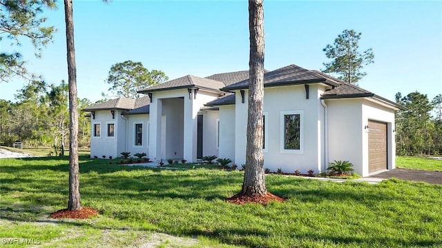 prairie-style house with a garage, driveway, a front yard, and stucco siding