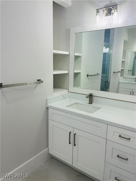 bathroom with a stall shower, vanity, and baseboards