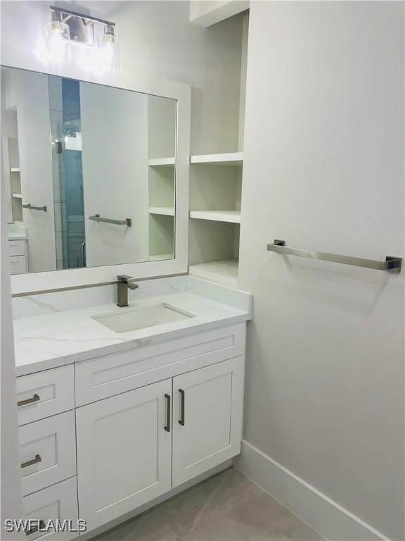 bathroom with a shower stall, baseboards, and vanity