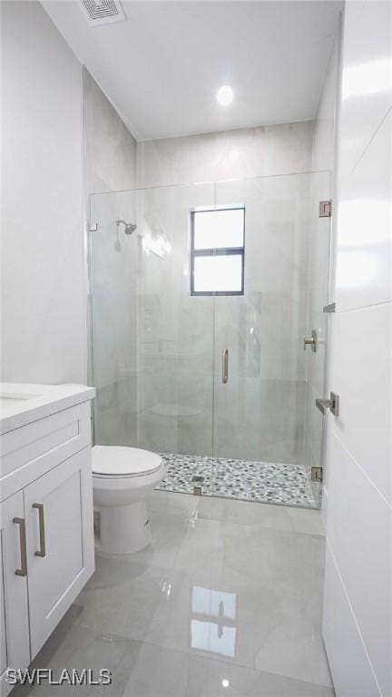 full bathroom featuring toilet, visible vents, a stall shower, and vanity