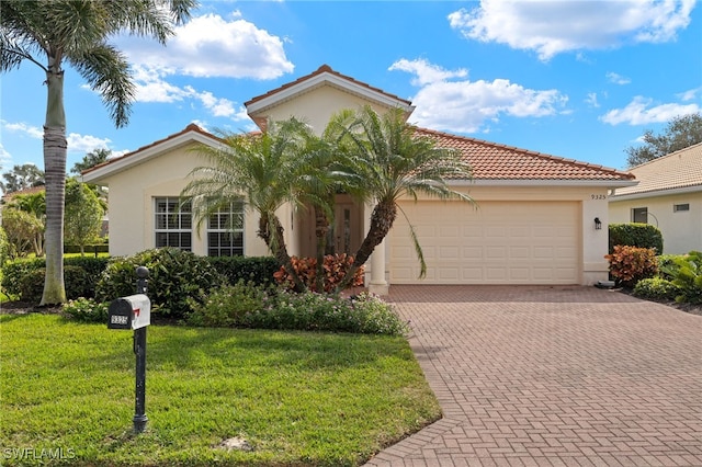 view of front of house with stucco siding, a tile roof, an attached garage, decorative driveway, and a front yard