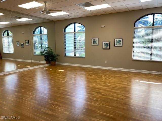 9325 La Bianco St, Estero, FL 33967 - workout room featuring a ceiling fan, a drop ceiling, baseboards, and wood finished floors