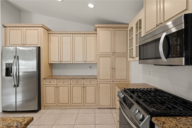 9325 La Bianco St, Estero, FL 33967 - kitchen featuring light tile patterned floors, cream cabinets, vaulted ceiling, appliances with stainless steel finishes, and light stone countertops