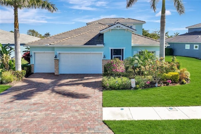 view of front of home featuring a garage, stone siding, decorative driveway, stucco siding, and a front lawn