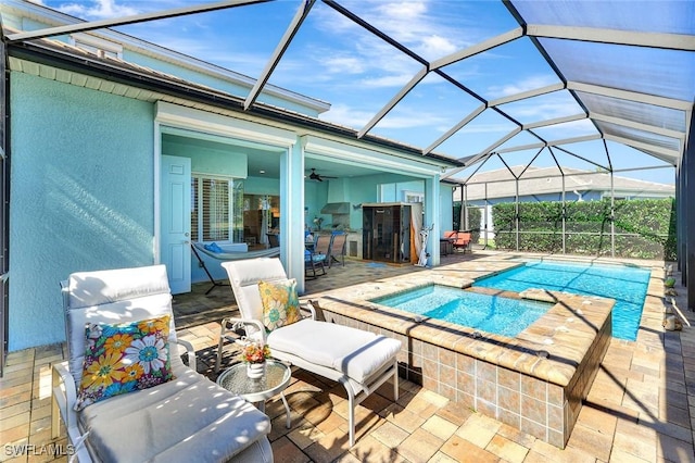 pool with glass enclosure, a patio area, and an in ground hot tub