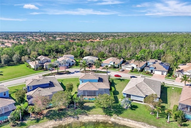 drone / aerial view featuring a wooded view and a residential view