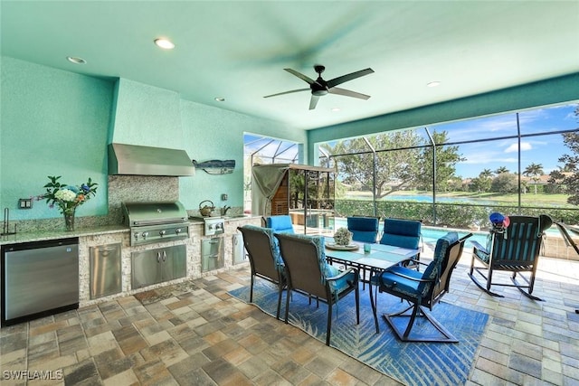 view of patio / terrace with area for grilling, glass enclosure, ceiling fan, a sink, and exterior kitchen