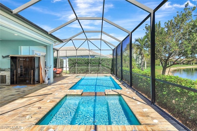 view of swimming pool featuring a patio, a water view, a lanai, and a pool with connected hot tub