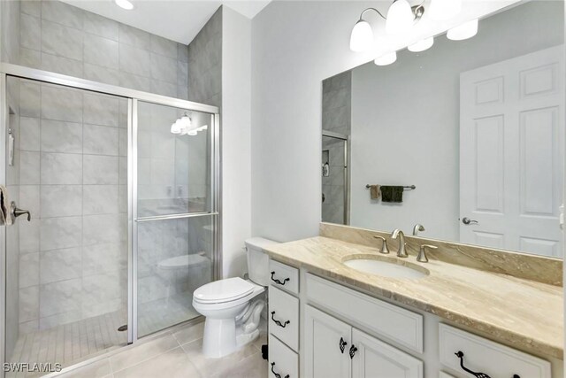 full bath featuring toilet, a stall shower, vanity, and tile patterned floors