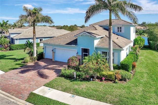 view of front of house featuring a front yard, decorative driveway, an attached garage, and stucco siding