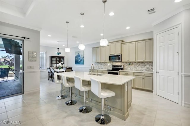 kitchen featuring stainless steel appliances, visible vents, backsplash, a sink, and a kitchen bar