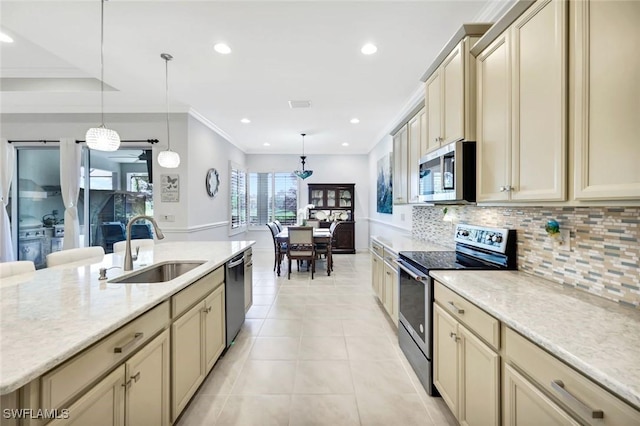 kitchen featuring stainless steel appliances, cream cabinetry, light tile patterned flooring, and a sink