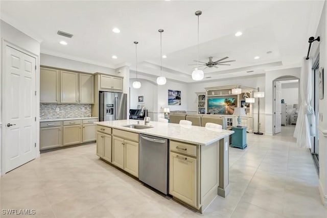 kitchen featuring arched walkways, a sink, appliances with stainless steel finishes, backsplash, and a raised ceiling