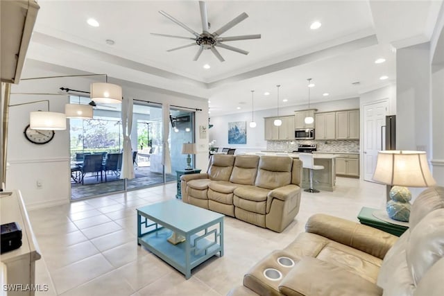 living area with light tile patterned floors, a tray ceiling, recessed lighting, and crown molding