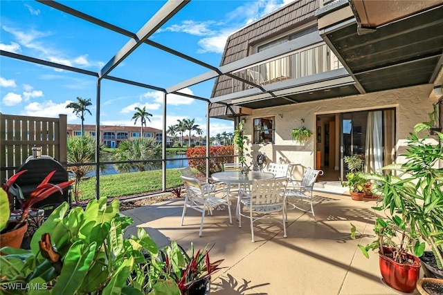 view of patio featuring a balcony, a water view, a lanai, and outdoor dining area