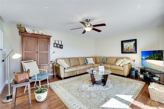 living area with wood finished floors, a ceiling fan, and baseboards