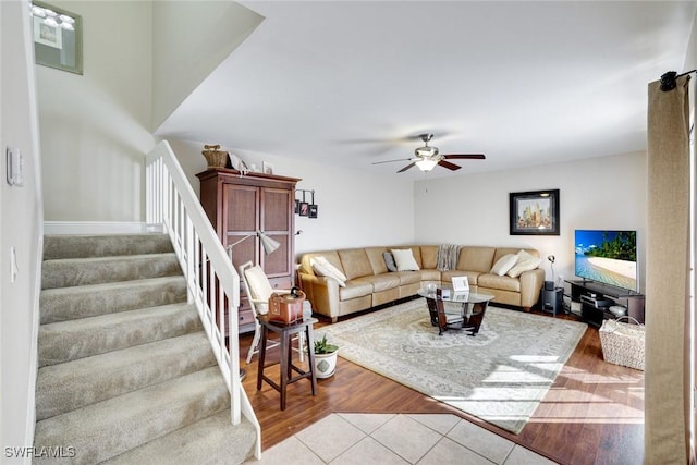 living room with ceiling fan, stairs, and tile patterned flooring