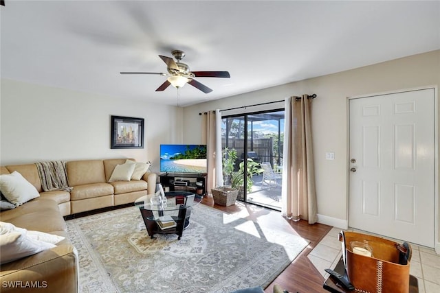 living room featuring baseboards and a ceiling fan