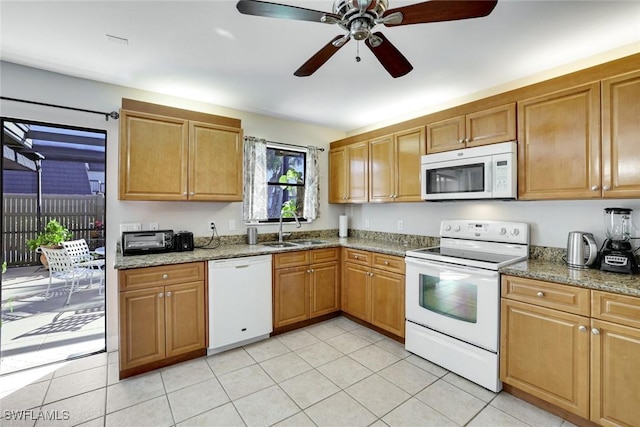 kitchen featuring white appliances, light tile patterned floors, stone counters, and a sink