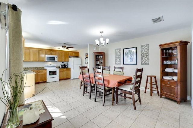 dining space featuring light tile patterned floors, ceiling fan with notable chandelier, visible vents, and baseboards