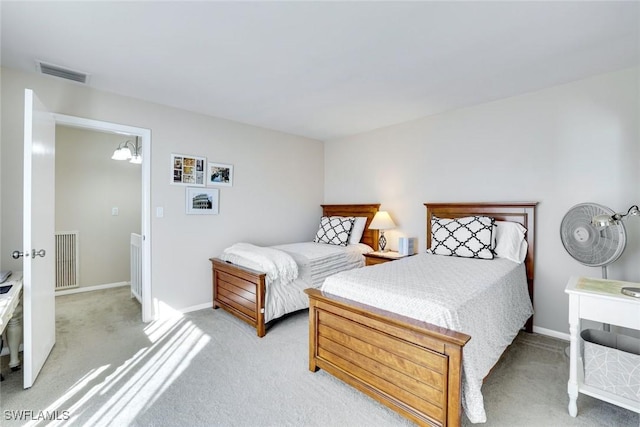 bedroom featuring baseboards, visible vents, and light colored carpet