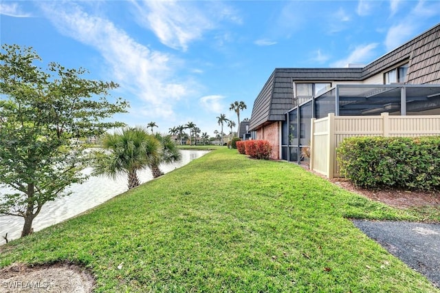 view of yard featuring a lanai and a water view