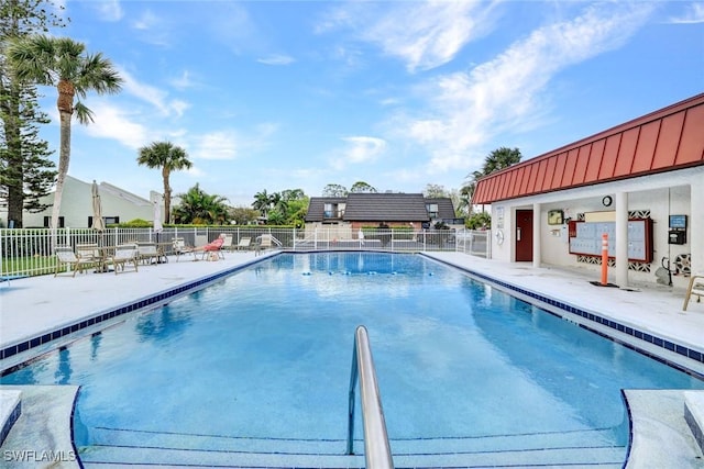 community pool featuring fence and a patio