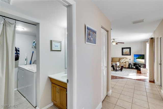 hall featuring visible vents, washer and dryer, and light tile patterned flooring