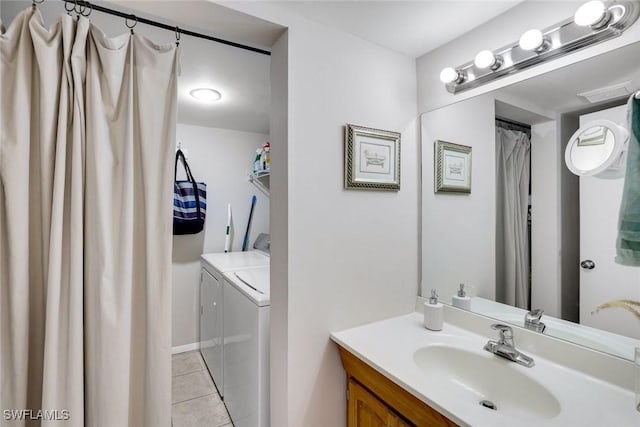 bathroom with separate washer and dryer, vanity, and tile patterned floors