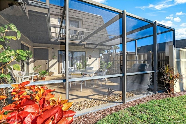 exterior space featuring glass enclosure, a patio, and fence