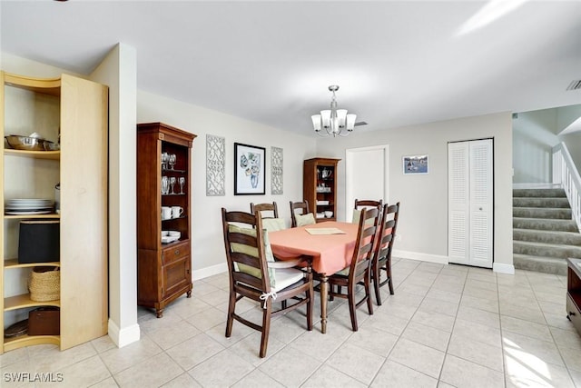 dining room featuring a chandelier, stairway, light tile patterned flooring, and baseboards