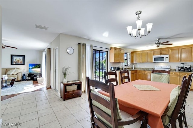 dining area featuring light tile patterned flooring, visible vents, and ceiling fan with notable chandelier