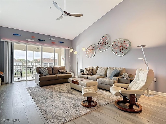 living room with ceiling fan, baseboards, high vaulted ceiling, and wood finished floors