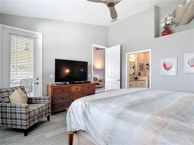 bedroom with visible vents, ensuite bath, light wood-style flooring, ceiling fan, and vaulted ceiling