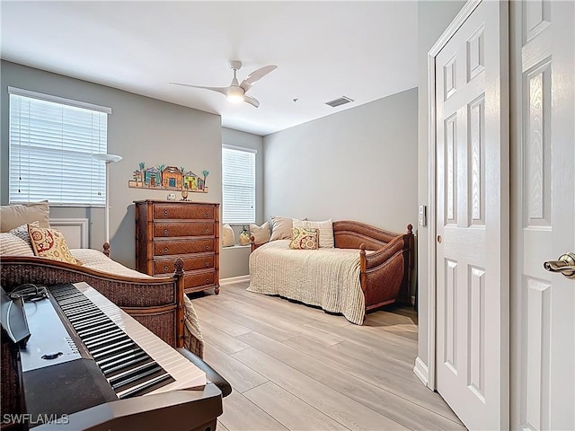 bedroom featuring visible vents, light wood-style floors, and a ceiling fan