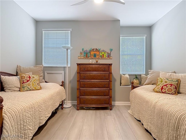 bedroom with baseboards, light wood-type flooring, and ceiling fan